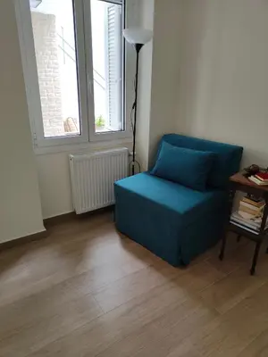 a living room with a blue couch and a window at Litseli in Athens