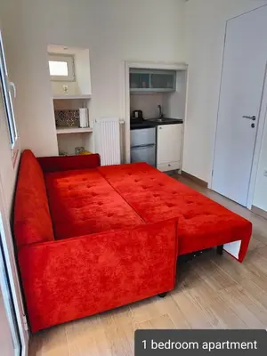 a red bed in a room with a kitchen at Litseli in Athens