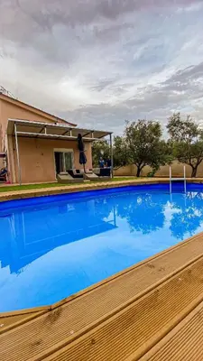 a swimming pool with blue water in front of a house at Villa Lagonisi in Aghia Marina