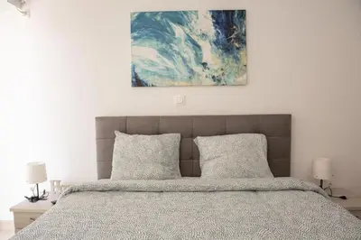 a bed with two pillows and a painting above it at Overlooking park flat close to the Piraeus Port-(DRAP-A7) in Piraeus