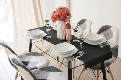 a glass table with chairs and a vase with flowers at Overlooking park flat close to the Piraeus Port-(DRAP-A7) in Piraeus