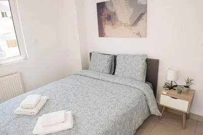 a bedroom with a bed with two towels on it at Overlooking park flat close to the Piraeus Port-(DRAP-A7) in Piraeus
