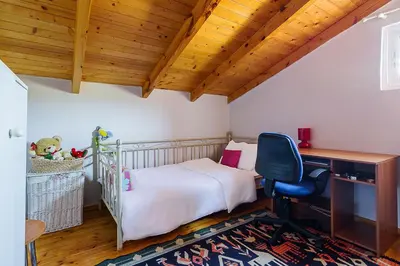 a bedroom with a bed and a desk and a chair at Sea Breeze Garden Maisonette - Porto Rafti by ΜΡS in Porto Rafti