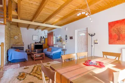 a living room with a table and a dining room at Sea Breeze Garden Maisonette - Porto Rafti by ΜΡS in Porto Rafti