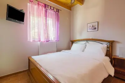 a bedroom with a bed with white sheets and a window at Sea Breeze Garden Maisonette - Porto Rafti by ΜΡS in Porto Rafti