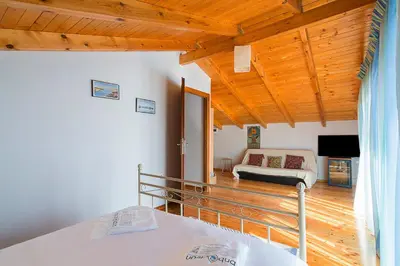 a bedroom with a bed and a living room at Sea Breeze Garden Maisonette - Porto Rafti by ΜΡS in Porto Rafti