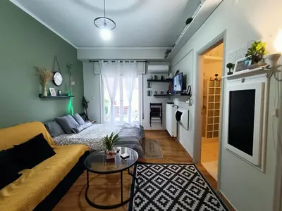 a living room with a couch and a table at Sunny Studio in Athens