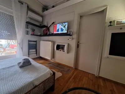 a bedroom with a bed and a tv on the wall at Sunny Studio in Athens