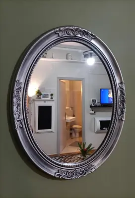 a mirror hanging on a wall with a bathroom at Sunny Studio in Athens