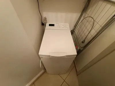 a washing machine sitting in a corner of a room at Sunny Studio in Athens