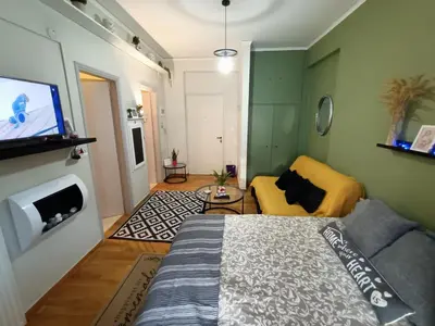 a living room with a bed and a tv at Sunny Studio in Athens