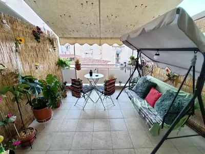 a balcony with a couch and a table with plants at Sunny Studio in Athens