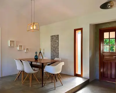 a dining room with a wooden table and white chairs at George's 1st floor dream house in Anavissos