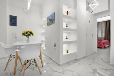 a white living room with a table and a chair at Athenian Destiny Suite in Athens