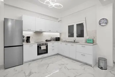a white kitchen with white cabinets and appliances at Athenian Destiny Suite in Athens