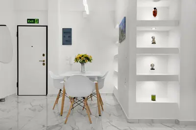a white dining room with a table and a chair at Athenian Destiny Suite in Athens