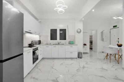 a large white kitchen with white cabinets and appliances at Athenian Destiny Suite in Athens