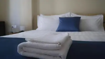 a pile of towels sitting on top of a bed at Dafni City Apartment 1 in Athens