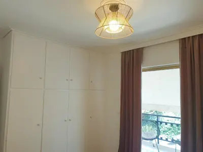 a room with a chandelier and a large window at EcoStay-Scandy,2bdr cozy apartment by the sea in Alimos in Athens