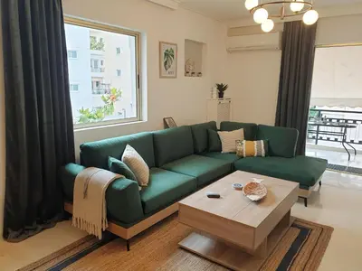 a living room with a green couch and a coffee table at EcoStay-Scandy,2bdr cozy apartment by the sea in Alimos in Athens