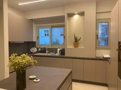 a kitchen with a table with a vase of flowers at Sapfo Luxury Apartment 1 in Athens in Athens