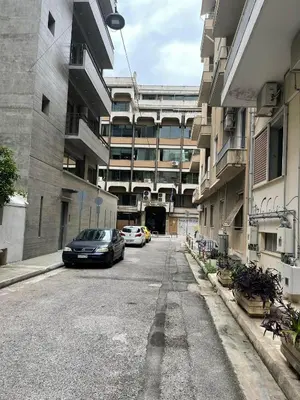 a parking lot with cars parked in front of a building at Sapfo Luxury Apartment 1 in Athens in Athens
