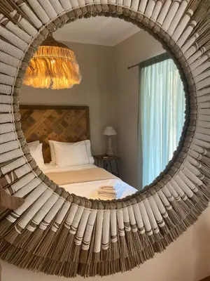 a mirror in a bedroom with a bed at Aelia Houses2 in Agia Marina Aegina