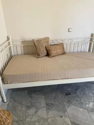 a white bench with two pillows on it at Aelia Houses2 in Agia Marina Aegina
