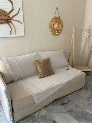 a white couch sitting in a living room at Aelia Houses2 in Agia Marina Aegina