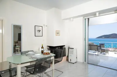 a dining room with a table and a view of the ocean at Phos Apartment by A&D Properties in Porto Rafti