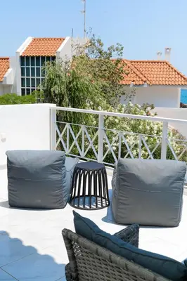 a patio with two pillows and a bench and a fence at Phos Apartment by A&D Properties in Porto Rafti