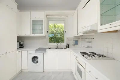 a white kitchen with a sink and a washing machine at Phos Apartment by A&D Properties in Porto Rafti