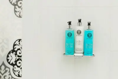 two bottles ofodorizers on a wall in a bathroom at Phos Apartment by A&D Properties in Porto Rafti