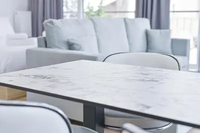 a white marble table and chairs in a room at Glassy Apartment in Athens