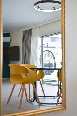 a mirror reflecting a table and chairs in a room at Milano Lux in Athens