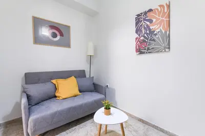 a living room with a blue couch and a table at Sweet & New Studio-Center Athens in Athens