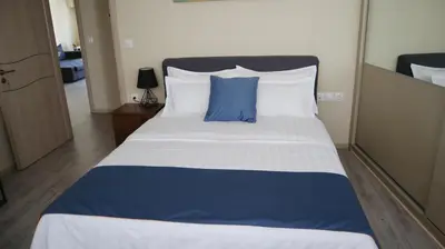 a large bed with a blue pillow on top of it at Dafni City Apartment 2 in Athens