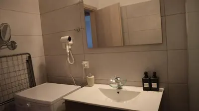 a bathroom with a sink and a phone on the wall at Dafni City Apartment 2 in Athens