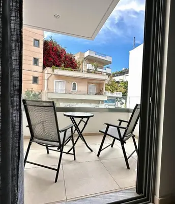 a patio with two chairs and a table on a balcony at Dafni City Apartment 2 in Athens