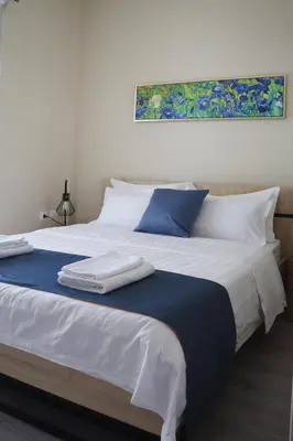 a large white bed with blue and white pillows at Dafni City Apartment 2 in Athens