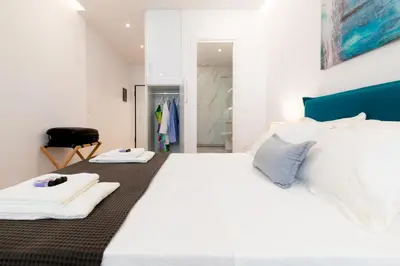 a bedroom with a large white bed with two towels on it at Minimal apartment in Plaka in Athens