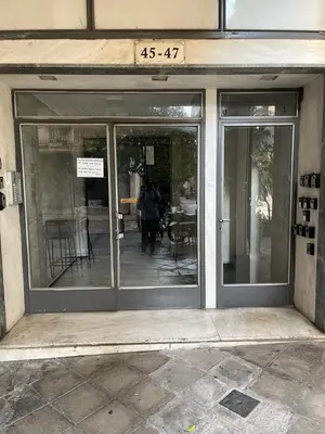 a store front with glass doors on a building at Minimal apartment in Plaka in Athens