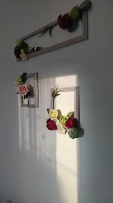 a bunch of flowers on a wall with a mirror at The Artemis House Project in Artemida