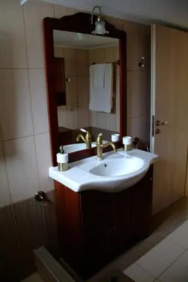 a bathroom with a sink and a mirror at The Artemis House Project in Artemida