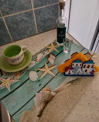 a table with a cup and a plate and a bottle of wine at Platinum Central Apartment in Athens