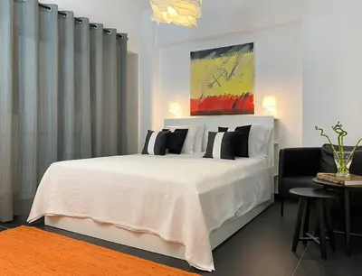 a bedroom with a white bed with black pillows at Executive Apartment in Kolonaki in Athens