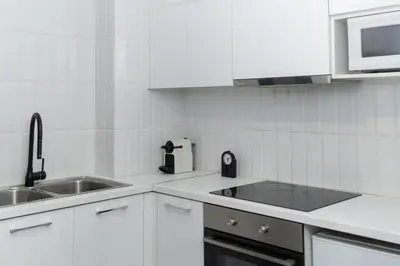 a white kitchen with a sink and a microwave at Executive Apartment in Kolonaki in Athens