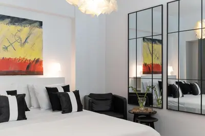 a bedroom with a white bed and a painting at Executive Apartment in Kolonaki in Athens
