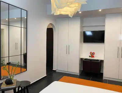 a bedroom with white cabinets and a table and a tv at Executive Apartment in Kolonaki in Athens