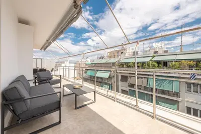 a balcony with furniture and a view of a building at Athens Del Sol Suite in Athens